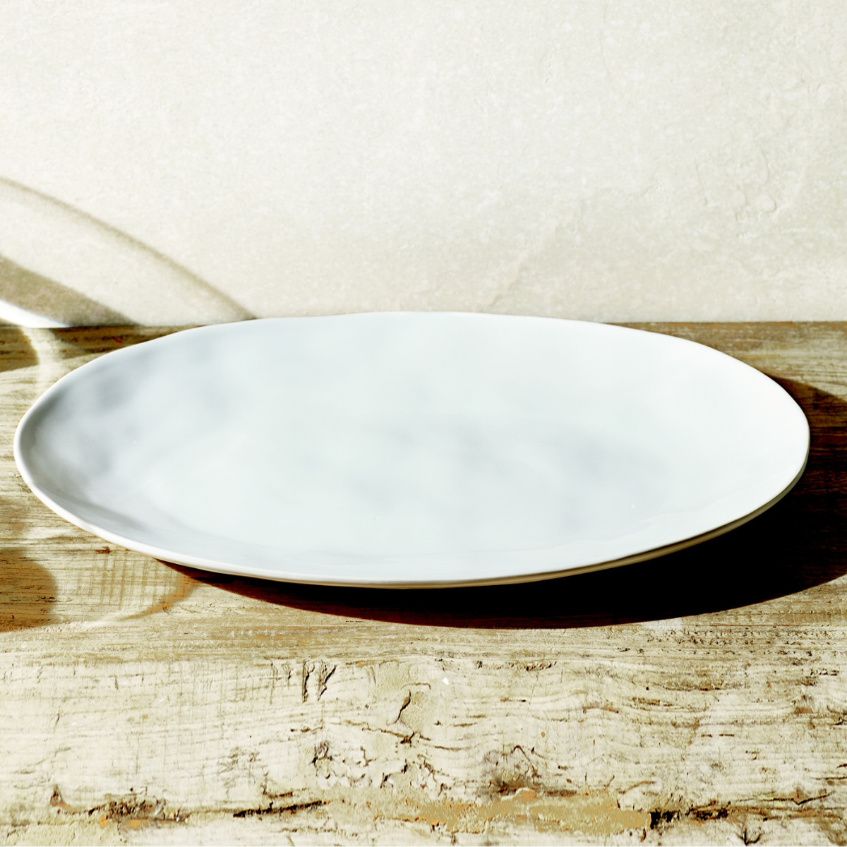 a white serving platter on a wooden table