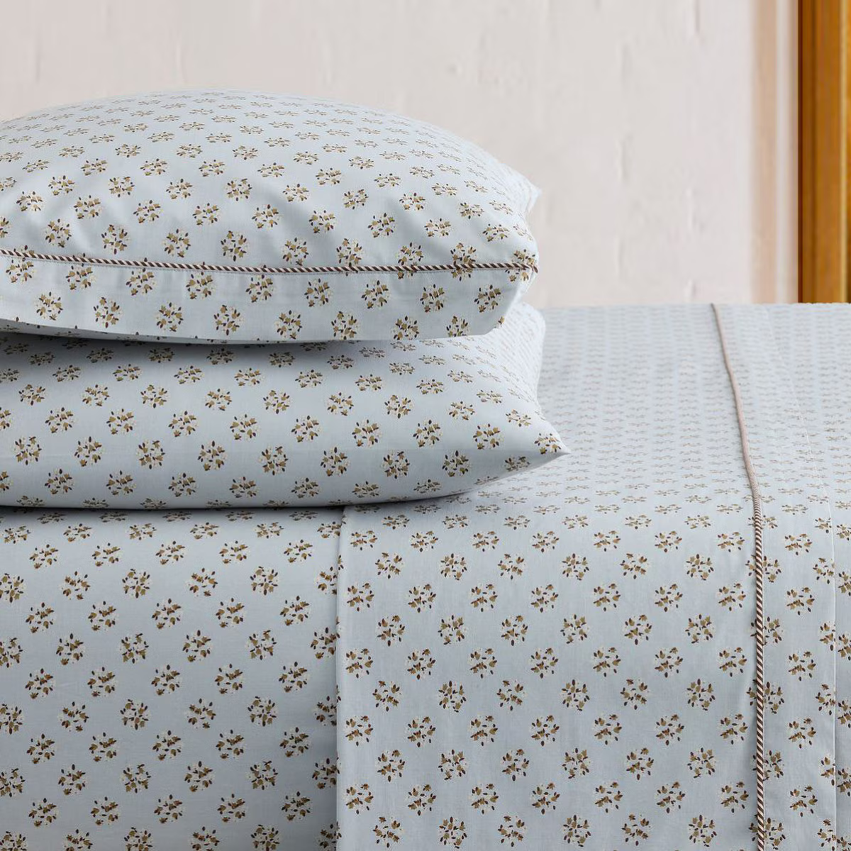 a pale blue bed set with small brown flowers