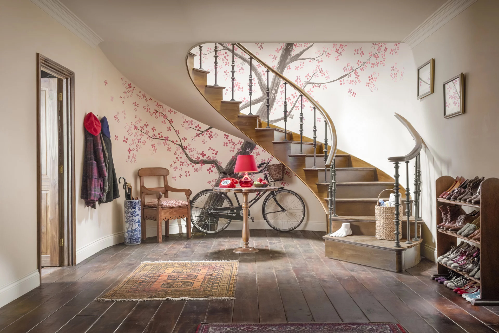 the living room from the paddington bear movie with a winding staircase and a tree mural