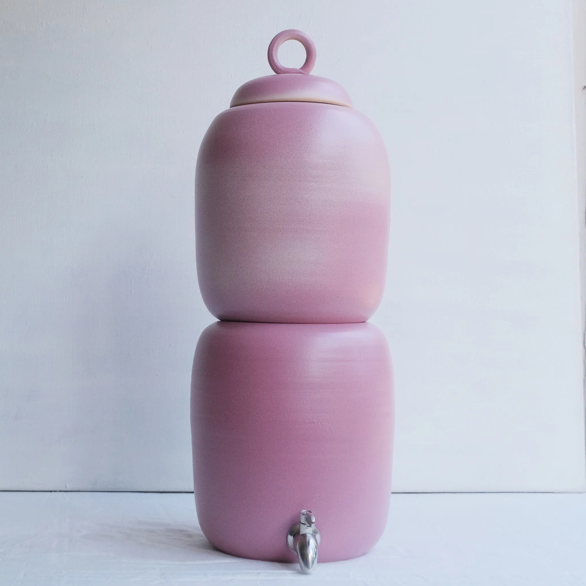Hand Thrown Colour Glazed Ceramic Gravity Fed Water Filter pictured in pink against a grey background
