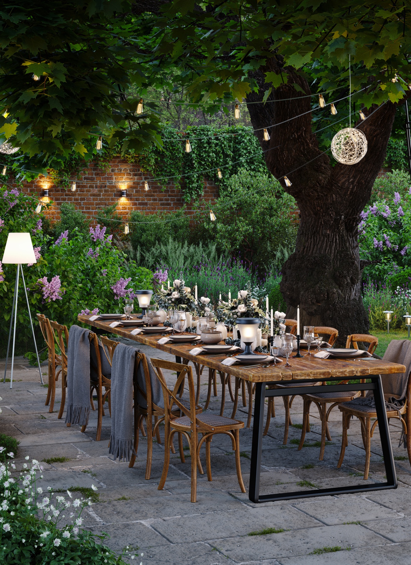 a long wooden outdoor table with chairs and outdoor lamps surrounded by trees and greenery