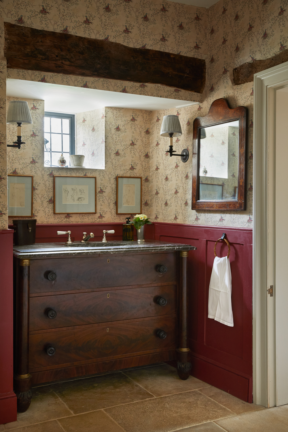 a vintage bathroom vanity pictured as the focal point of a country home, also pictured are wall lights and a mirror with an exposed beam