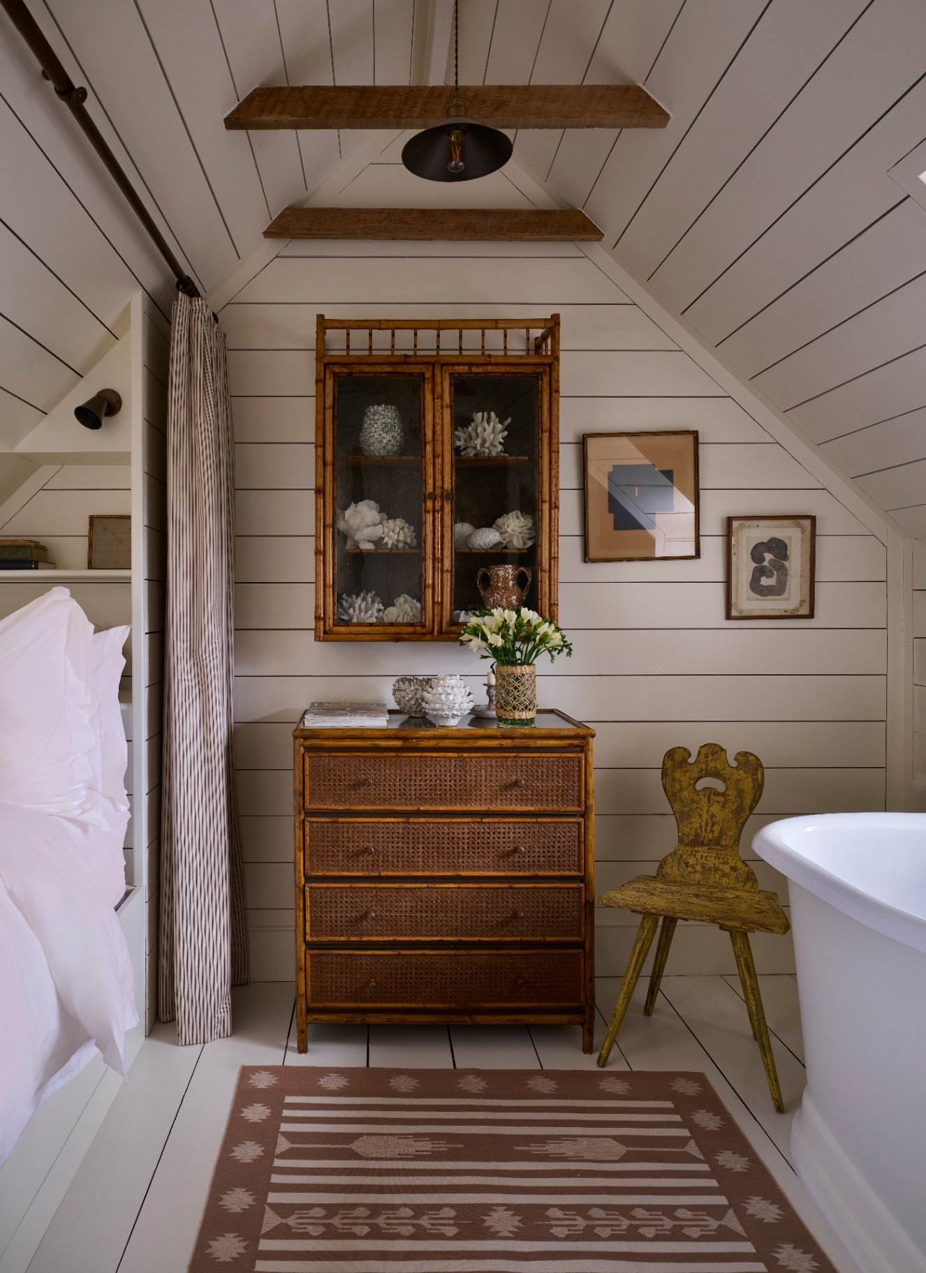 a bathroom with rattan bamboo drawers and a matching wall cabinet on a white panelled wall