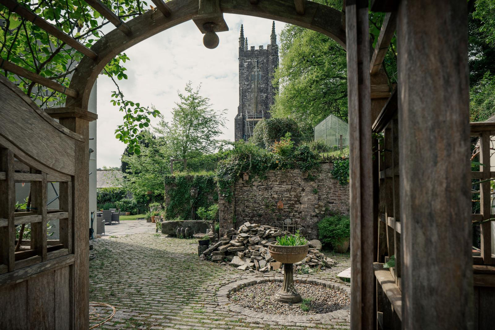 a courtyard garden with a view of an old church spire