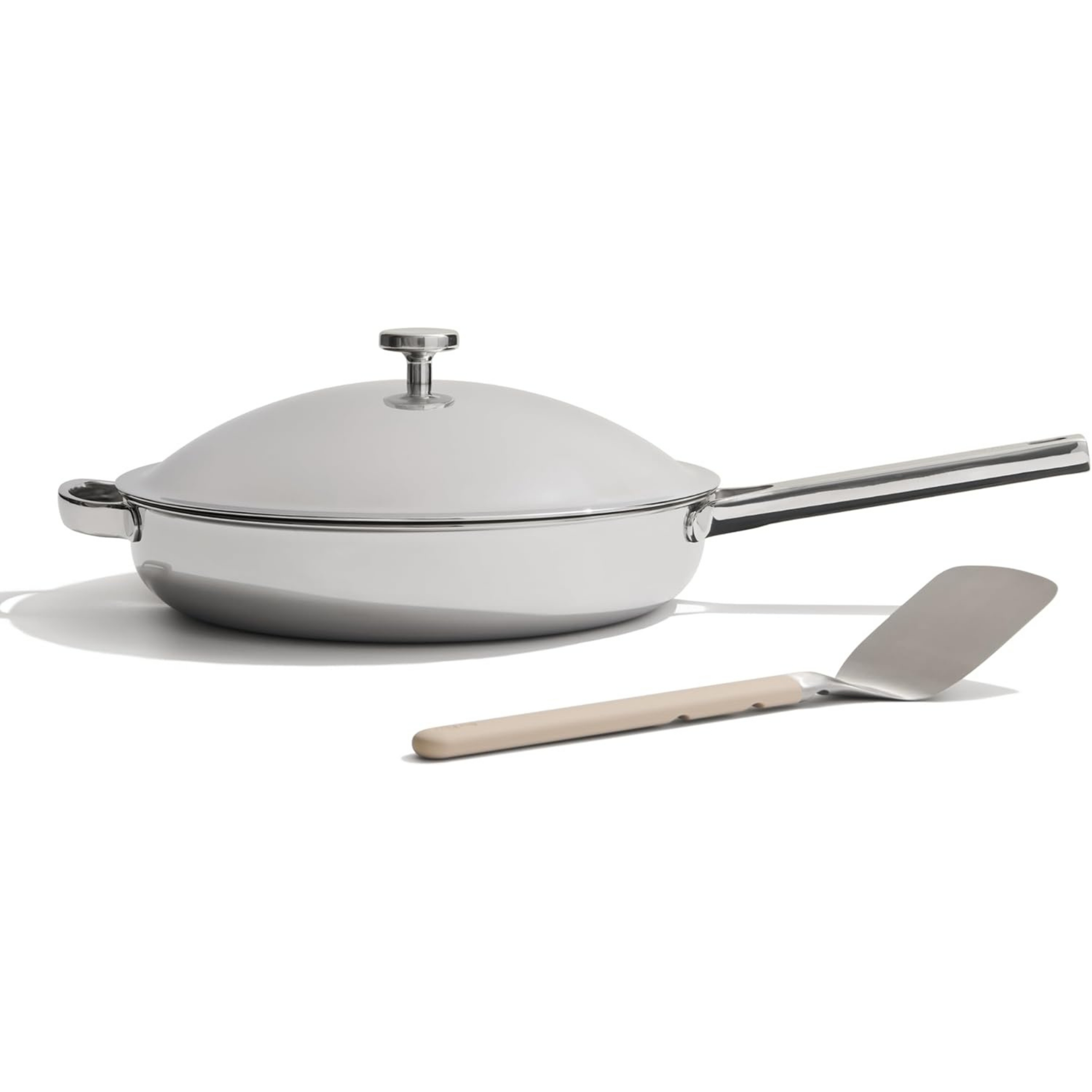 Our Place Titanium Always Pan Pro pictured in grey on a white background with non stick spatula tool