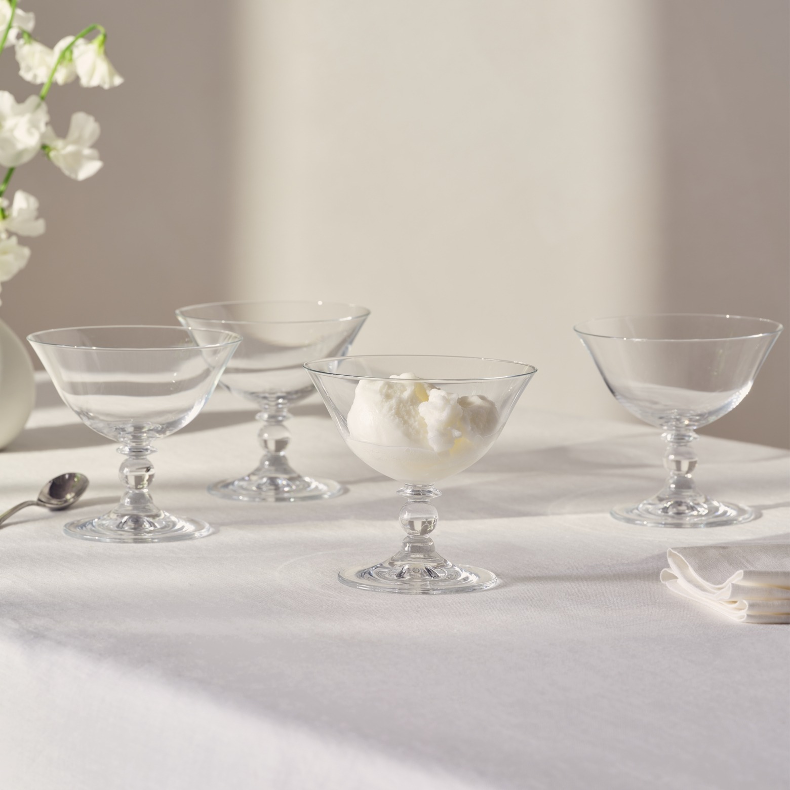 set of 4 clear ice cream bowls on a white table cloth