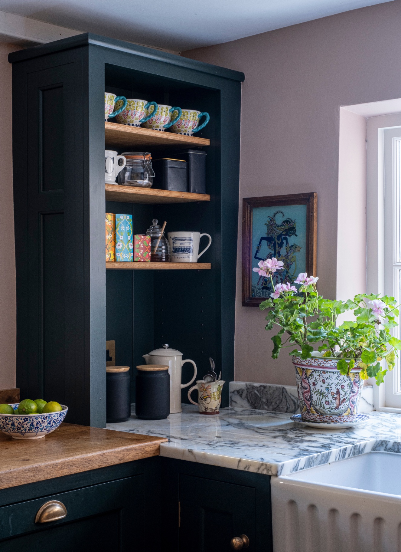 a kitchen corner with white marble countertops and a large dark navy open shelving unit on top of the counter