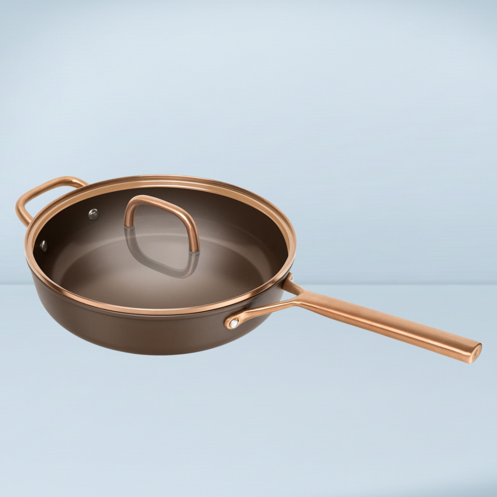 a brown and bronze saute pan with a glass lid