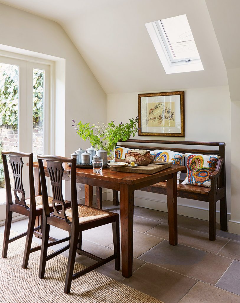 A dining nook with antique table, chairs and dining bench in Henry Bickerton's London home