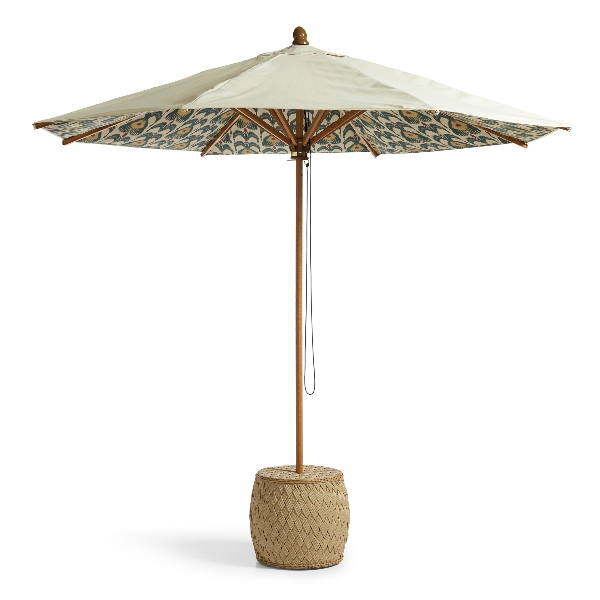a cream parasol with an ikat patterned underside, a wooden and rattan pole and a rattan base