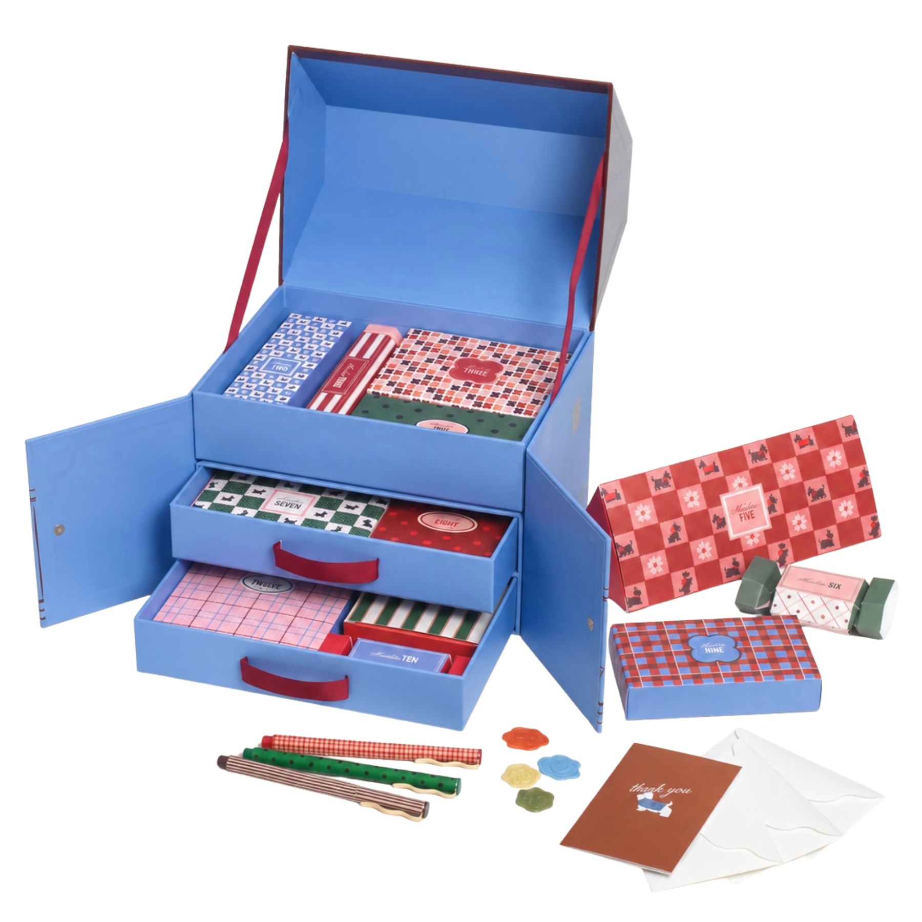 Open blue Papier stationery advent calendar box with pull–out drawers displaying pattern–printed boxes, notebooks, pens, and paper accessories.