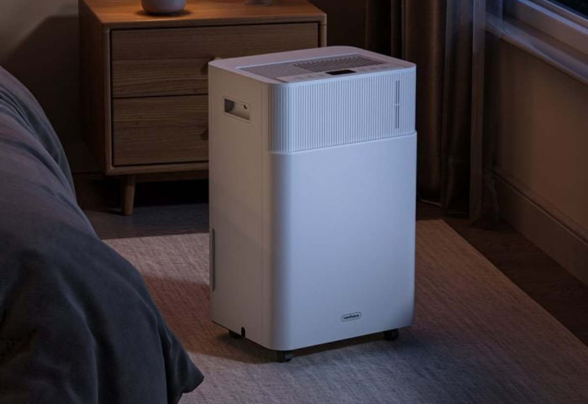 a white dehumidifier in a dark room on a pale rug