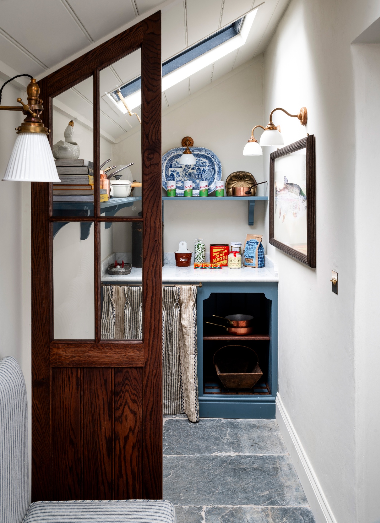 a utility room area with sloped ceilings, a dark wooden half door, blue joinery, a marble countertop and a skirt under the counter