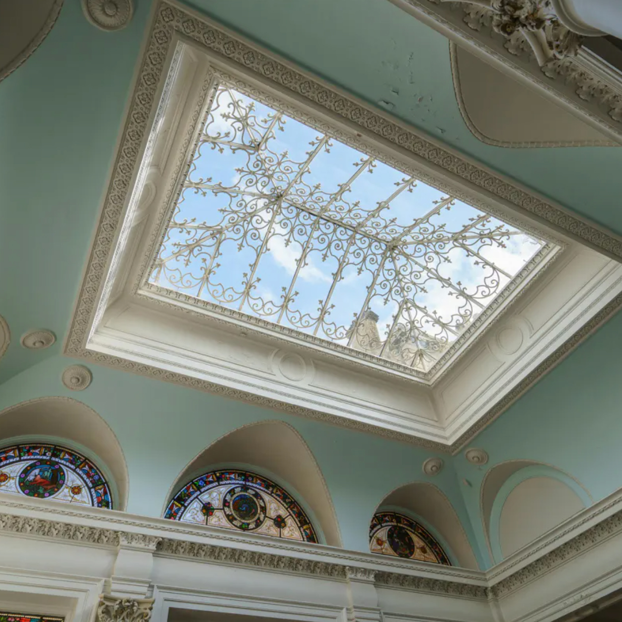 inside of Rendcomb park estate pictured beautiful windows next to duck egg blue walls adorned on the inside of the mansion