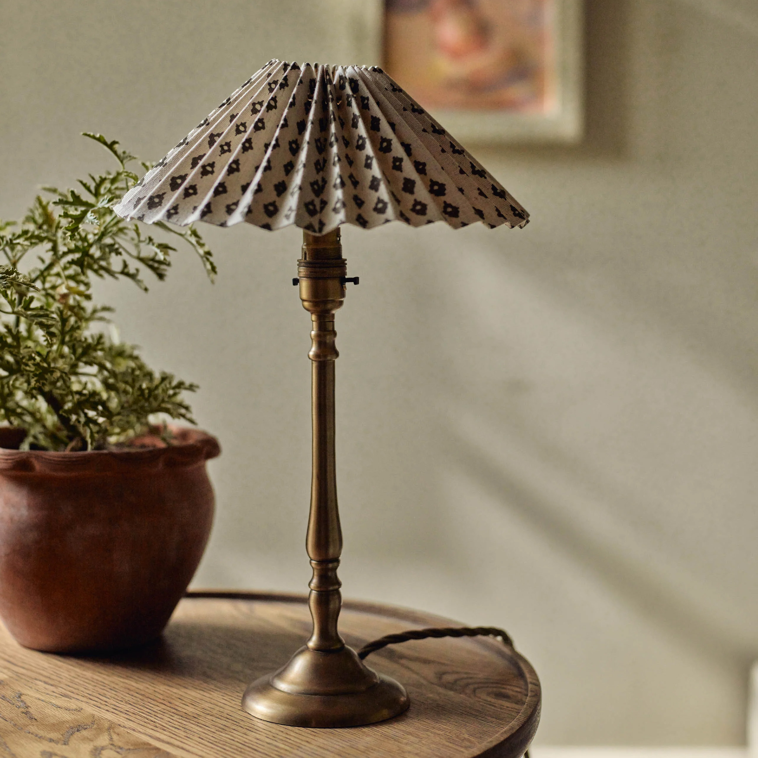 a brass lamp with patterned pleated lamp
