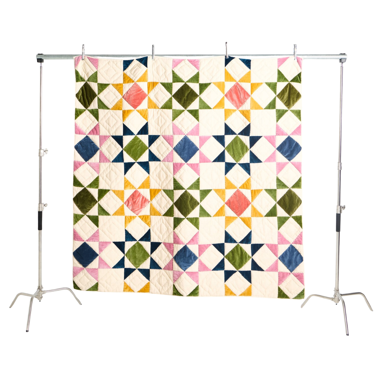 a patchwork quilt with a cream base and green, pink, yellow and blue star patterns