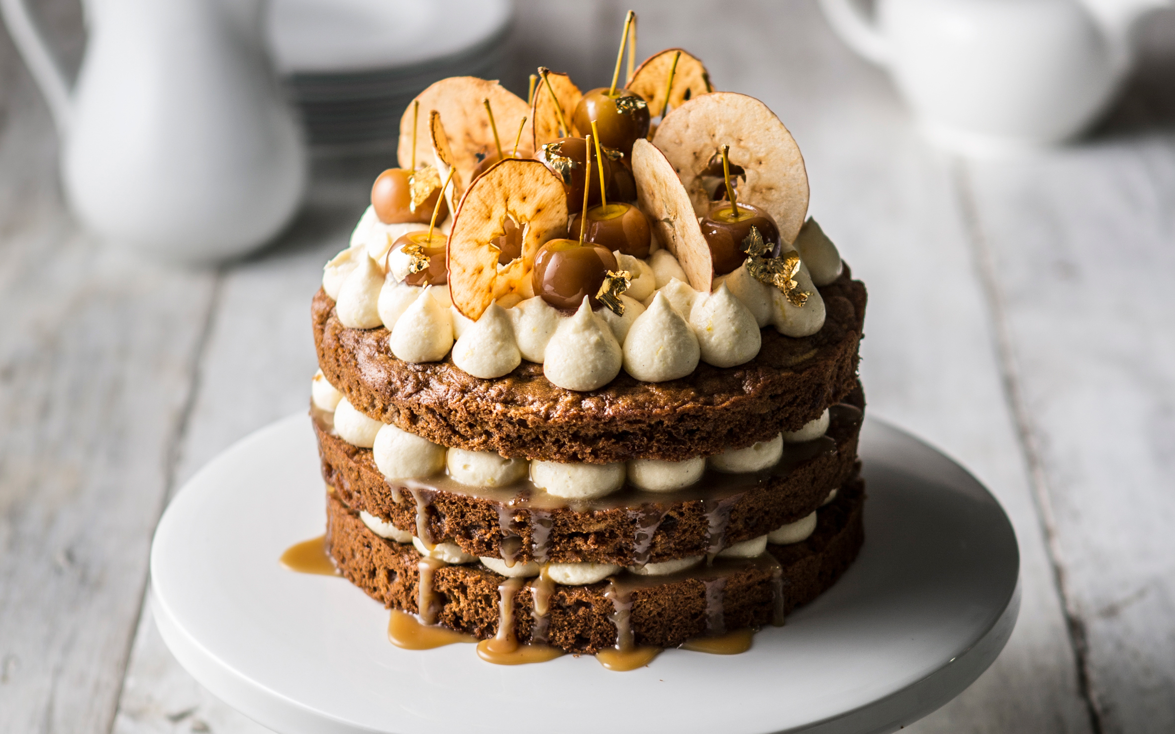 three tier toffee apple cake on a white stand