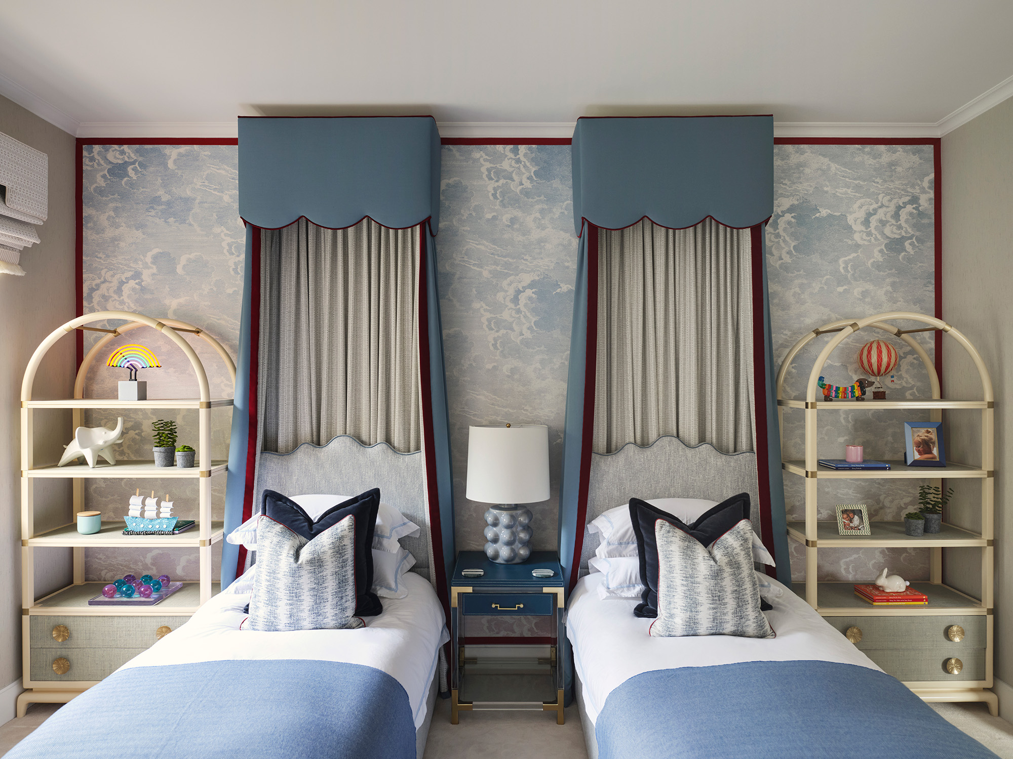 a childrens bedroom with twin beds each with a blue canopy