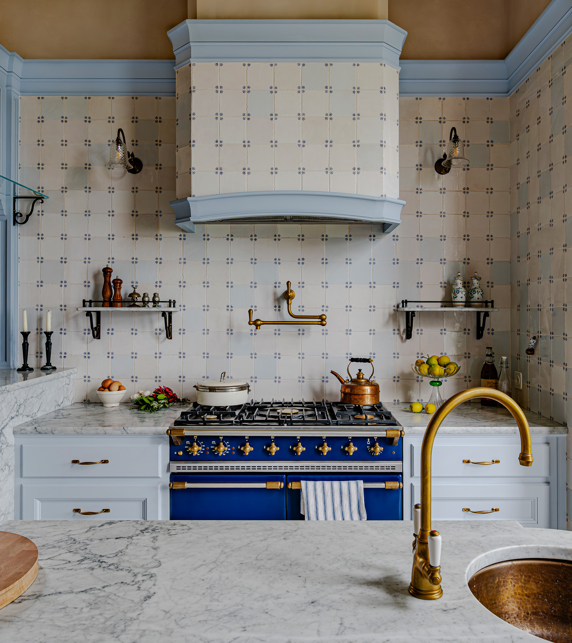 a blue kitchen with a blue range cooker and gold sink