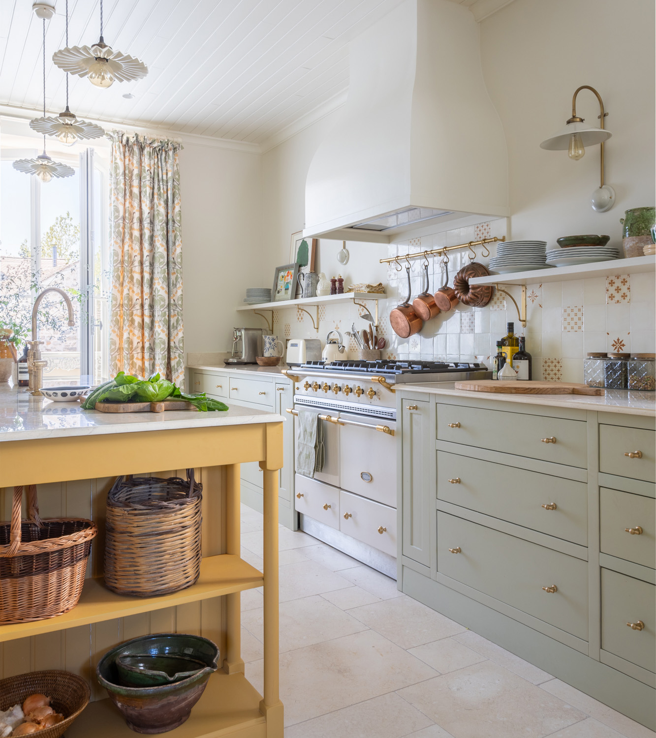 pots and pans hung in a kitchen with sage green cabinets