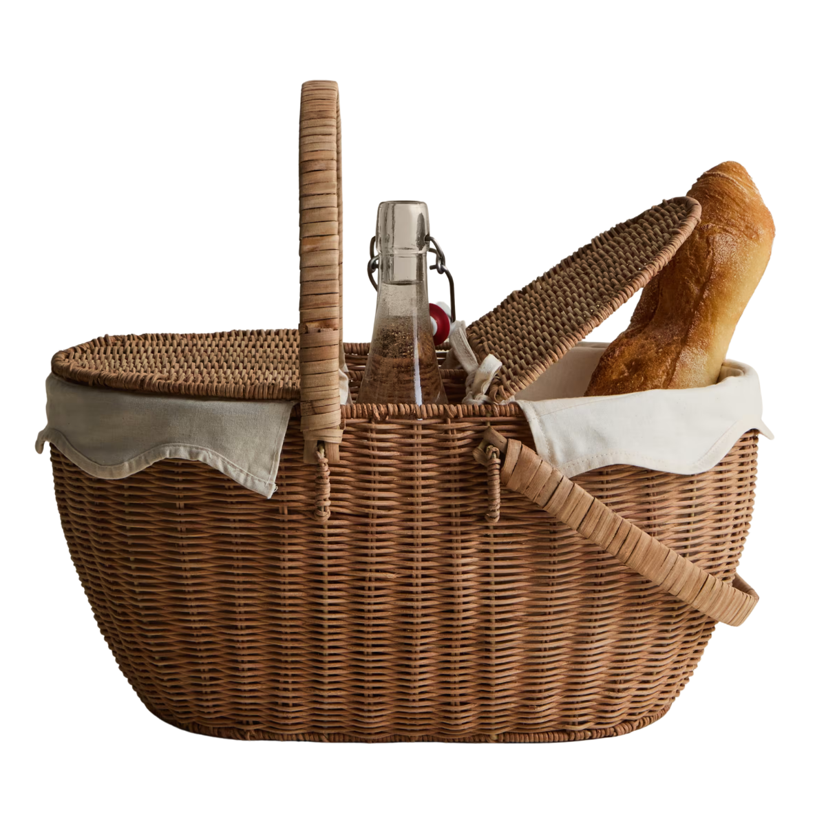 A picnic basket with a cream lining, a bottle in the centre and a baguette poking out