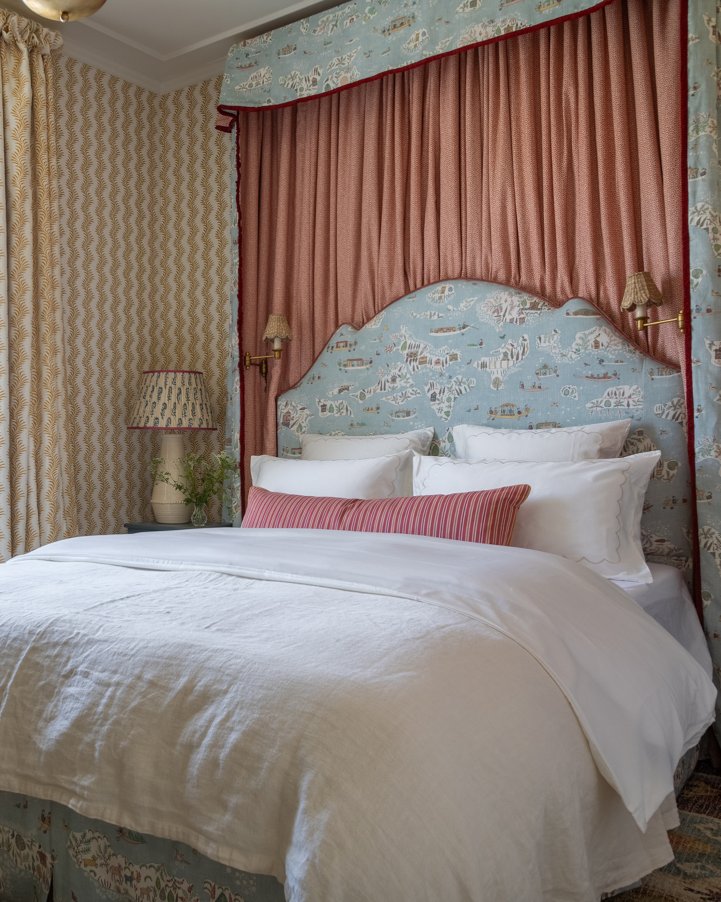 a bedroom with a bed with a blue illustrated headboard and matching canopy and white bedding