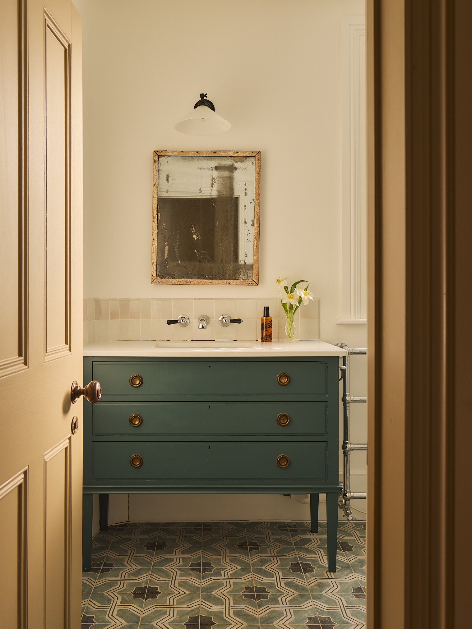 an antique style dresser as a vanity pictured in a bathroom with a mirror hanging above it