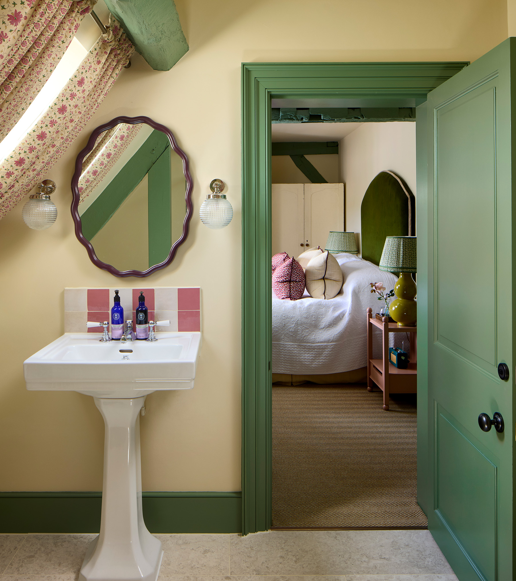 pale yellow en suite with green skirting board and door and door frame looking out onto the bedroom