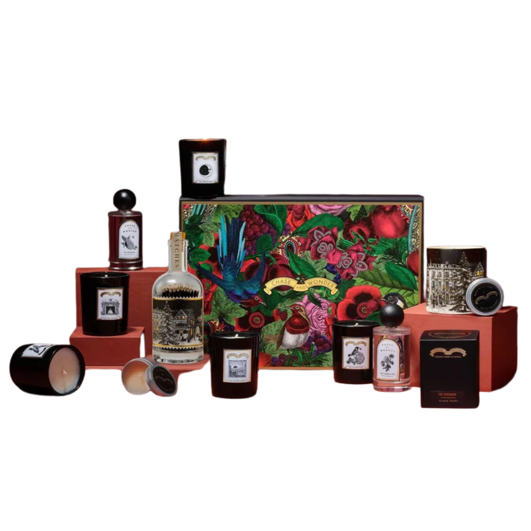 Chase and Wonder advent calendar box with a colorful botanical illustration, surrounded by scented candles, room sprays, and a glass match bottle