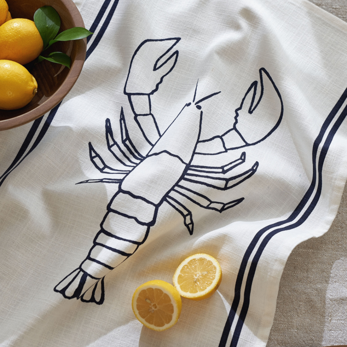 white tea towel with a navy lobster illustration