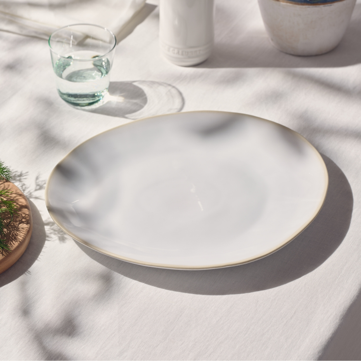 a cream serving plate on a white table cloth