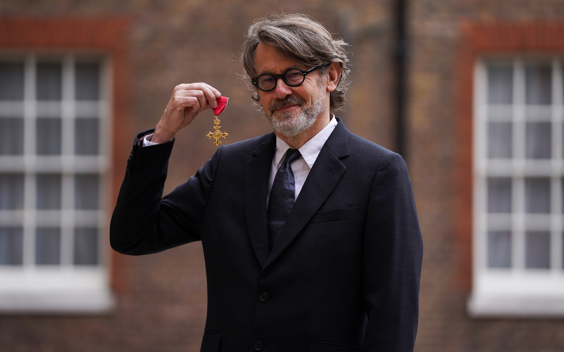 food writer nigel slater holding his obe medal