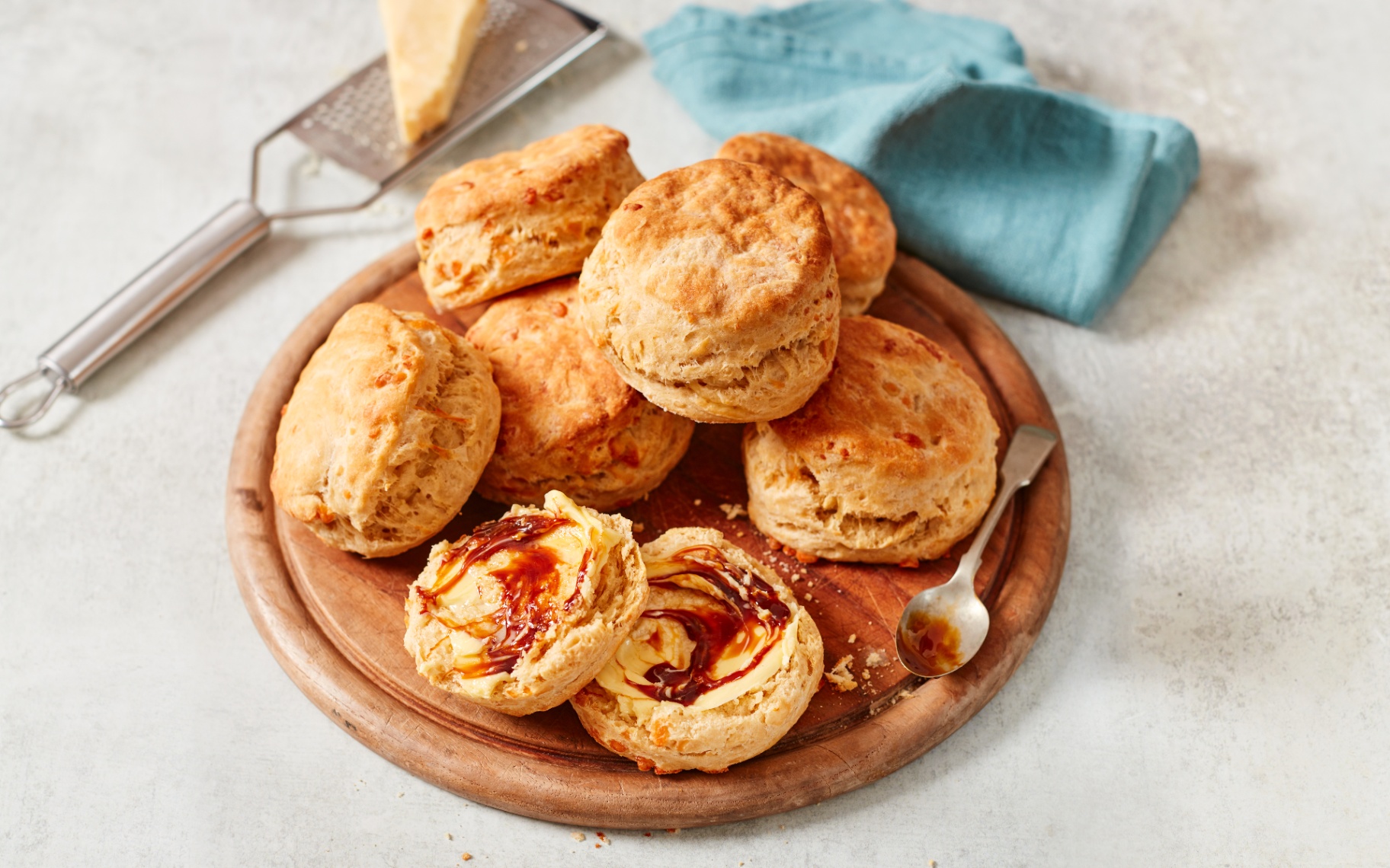 a pile of marmite and cheese scones on a round wooden serving board