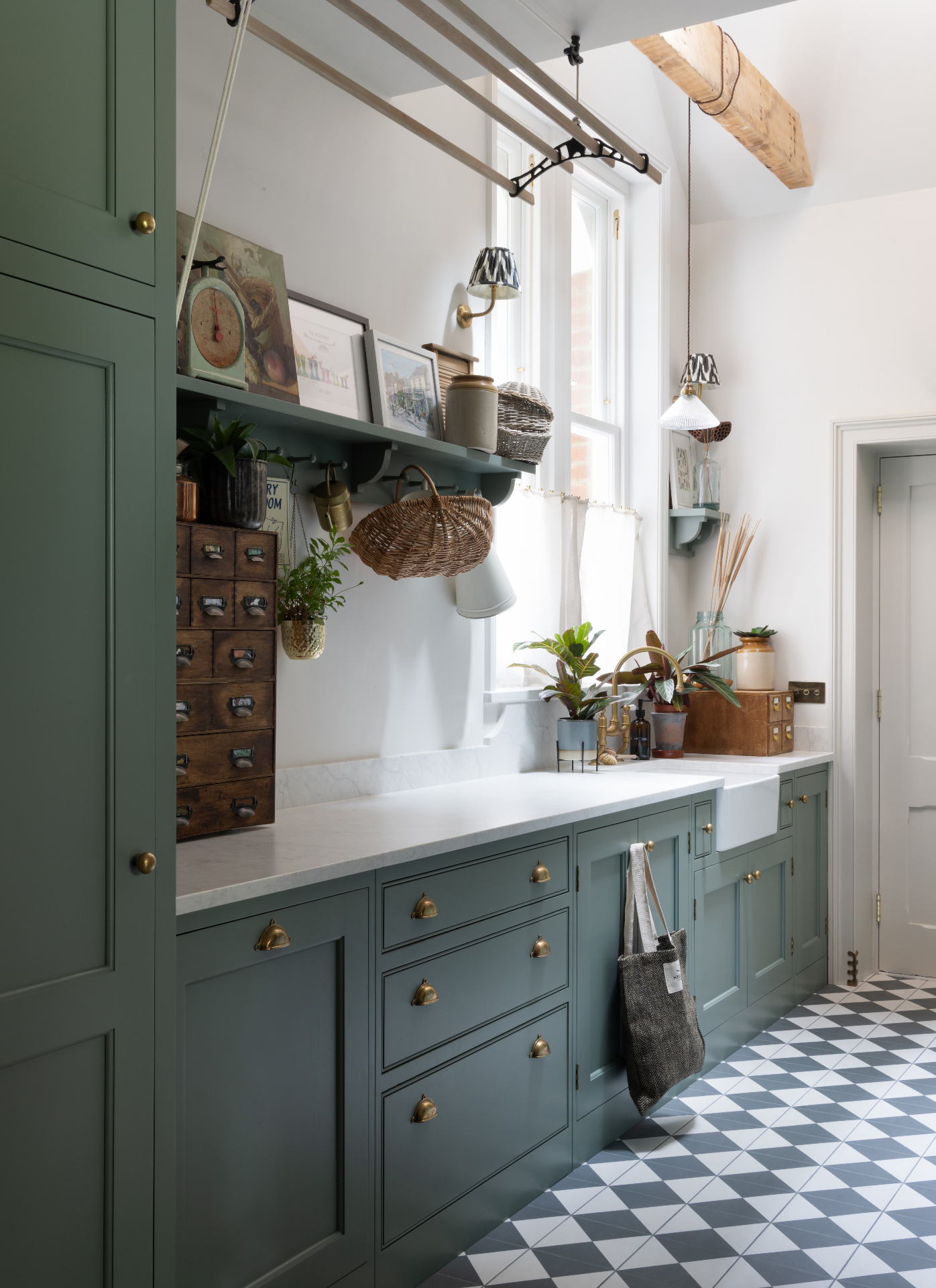 a kitchen with dark blue cabinets, checkerboard flooring, white marble countertops and a shelf with art