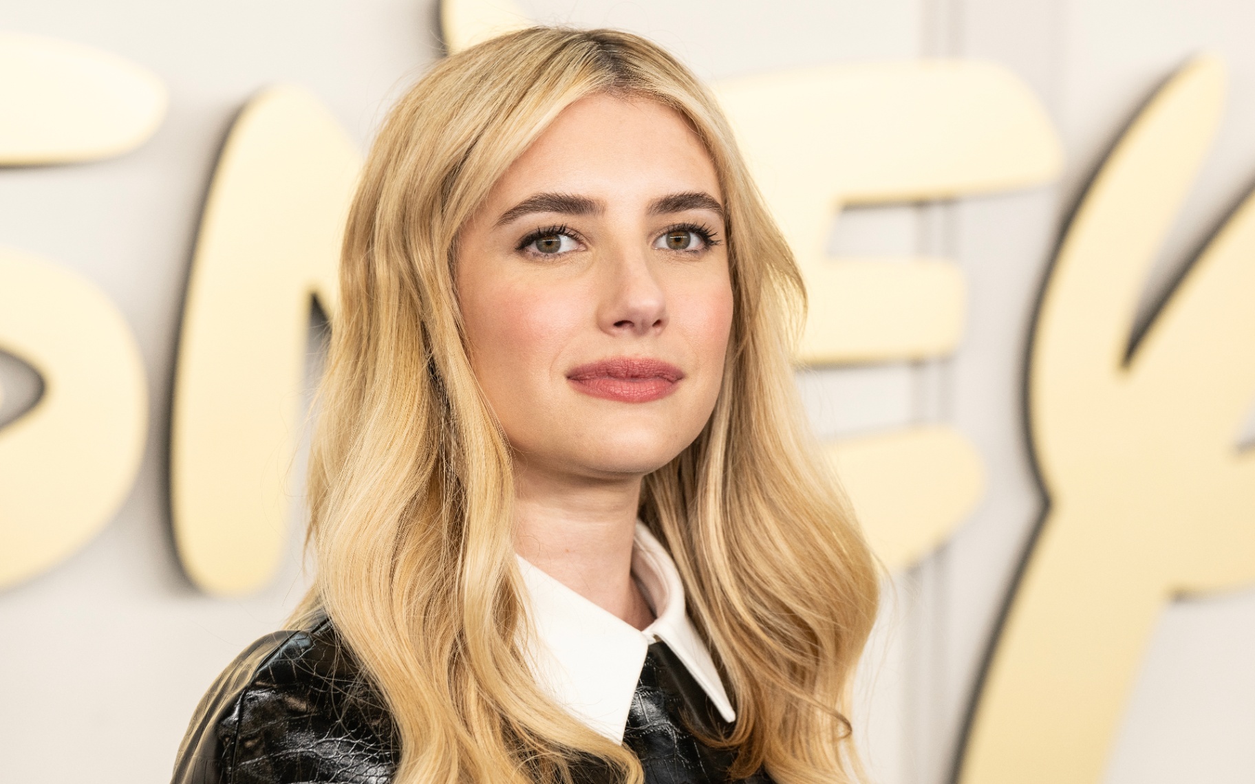 The actress emma roberts wearing a black dress with a white collar