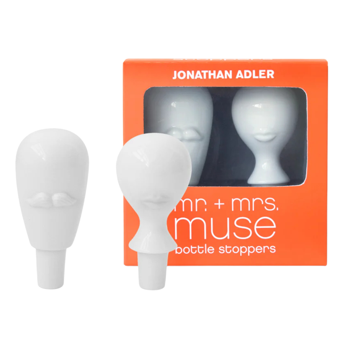 a set of two white head shaped bottle stoppers, one with a moustache and one with lips in front of its orange box