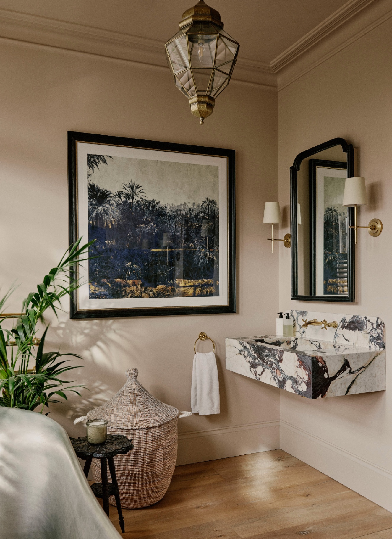 a bathroom with beige walls, a large square framed paitning and a black and white marble vanity