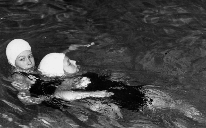 Princess Elizabeth wins an award for life-saving at the Children's Challenge Shield Competition, 1939 showing two little girls in a swimming pool wearing swimming caps