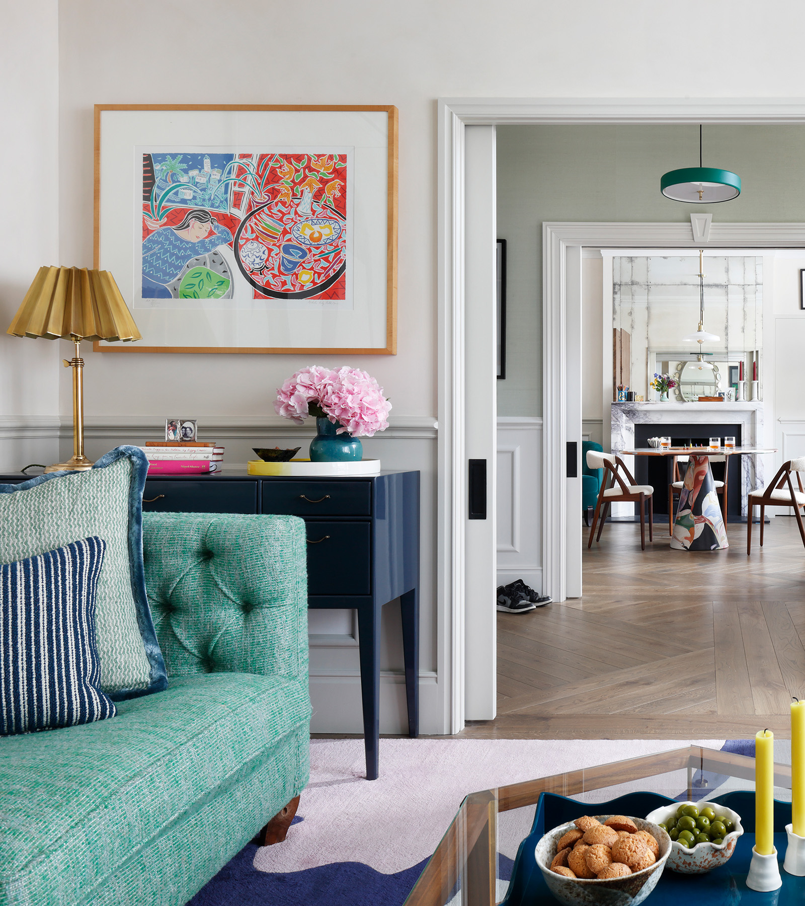 a white drawing room with green sofa
