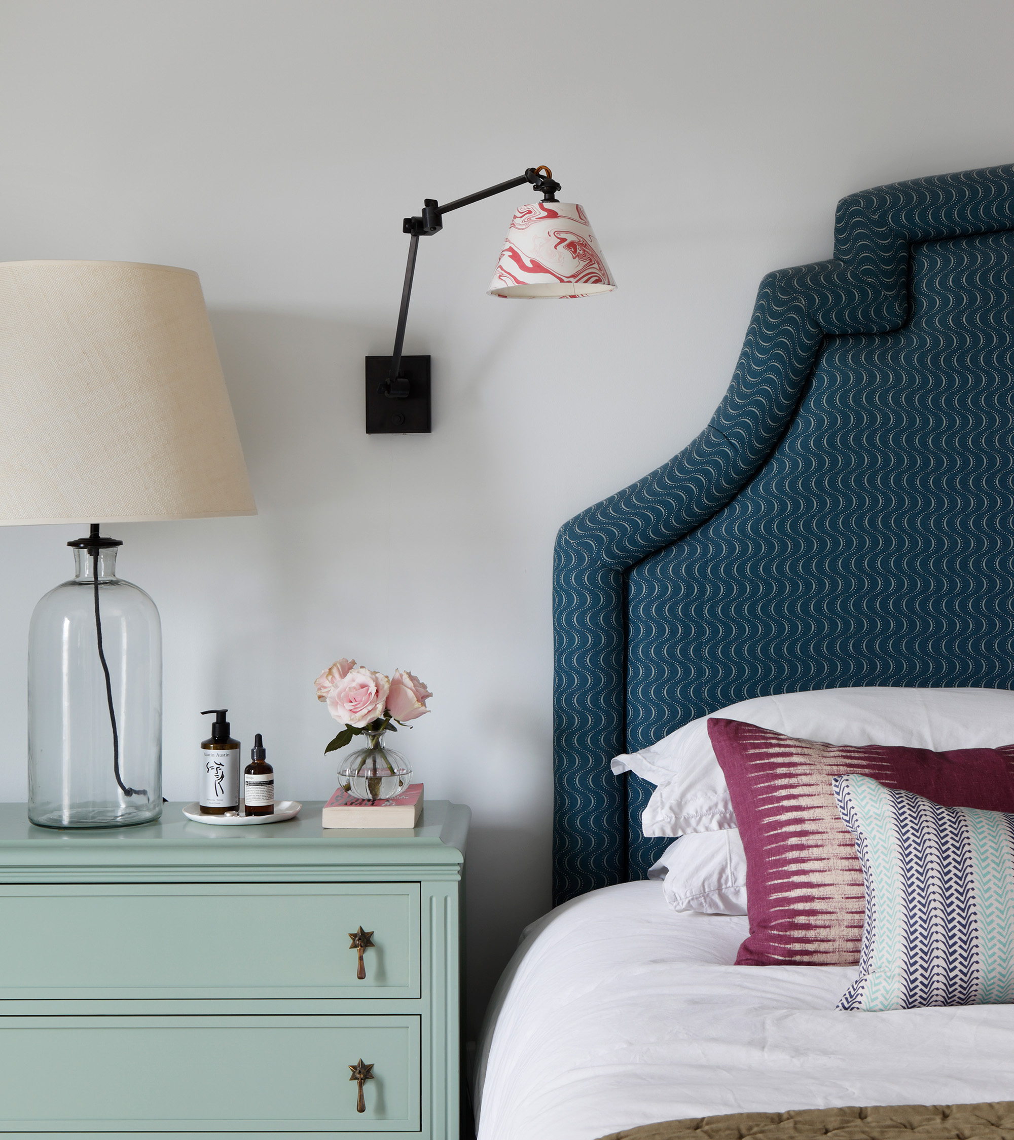 a bedroom with white balls and dark blue headboard