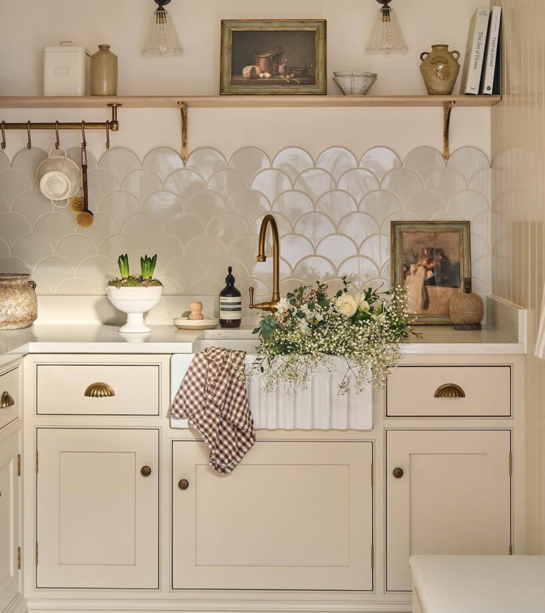 a cream painting kitchen with arched pearl tile splashback