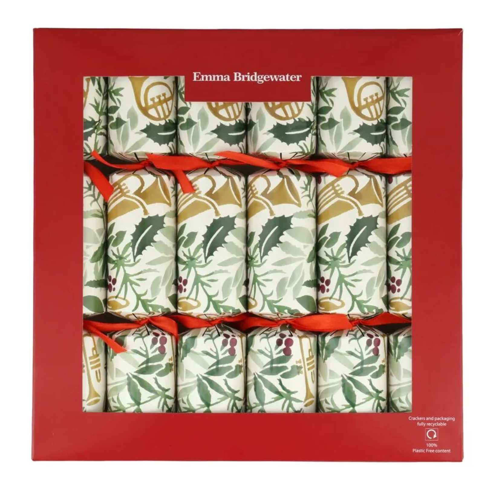 A box of Emma Bridgewater Christmas crackers in red packaging. Visible through the window, the paper crackers feature festive botanical prints of holly, berries, and brass instruments in green, gold, and red, tied with red ribbons.