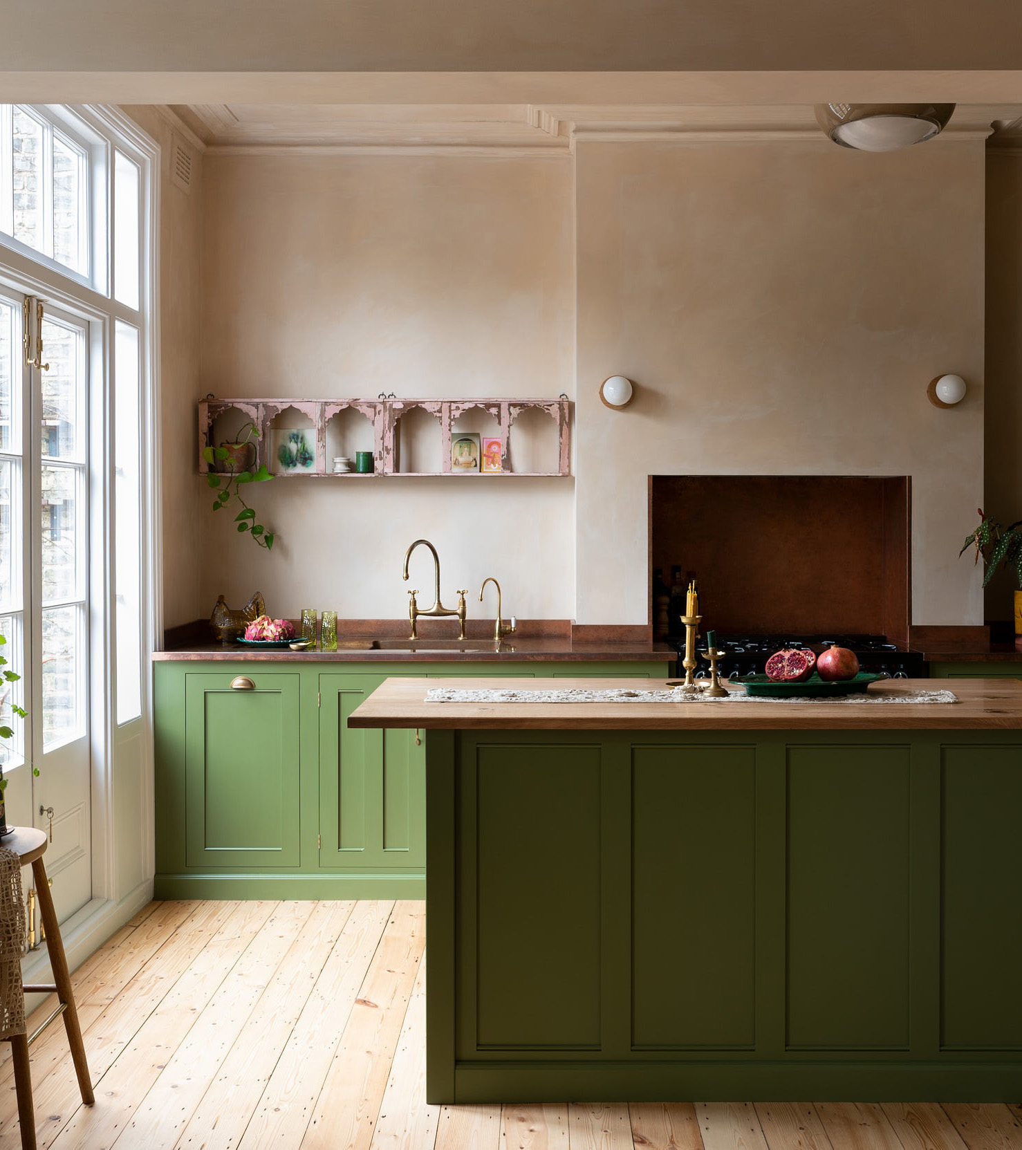 a green kitchen with pale pink cabinet