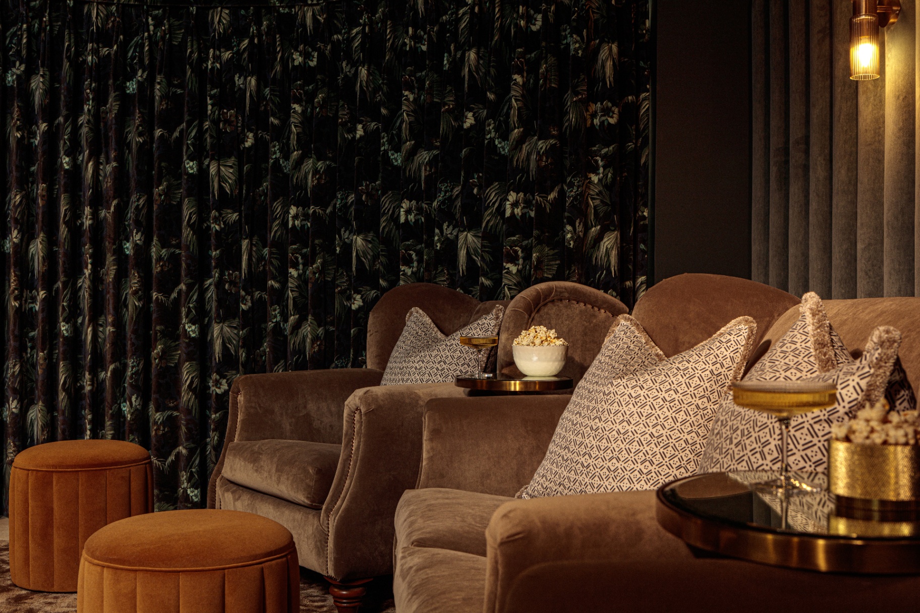 close up of grey velvet sofas in a cinema room with bowls of popcorn