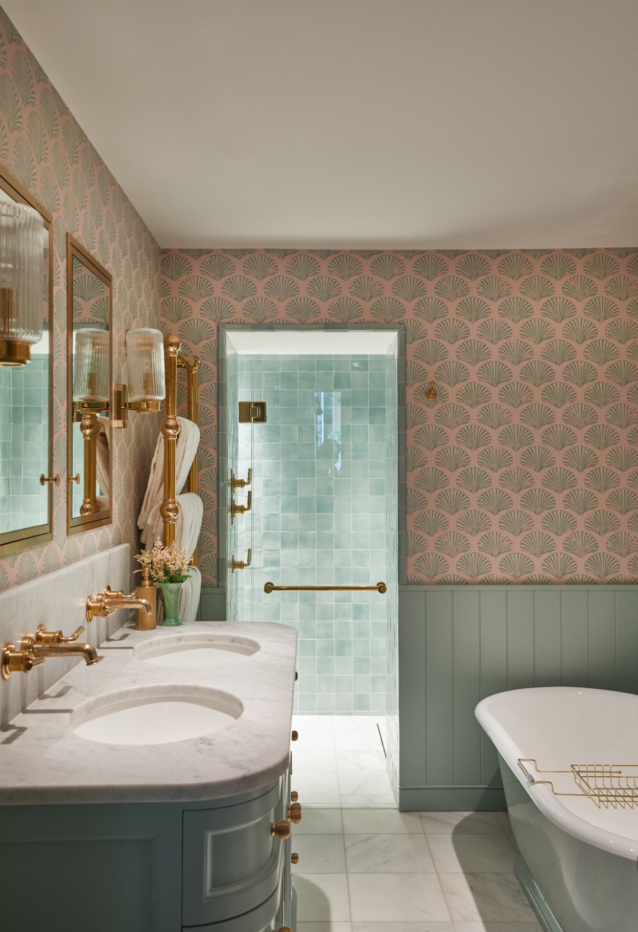 a luxury bathroom design featuring a statement custom made bespoke vanity, roll top bath and shower, with statement pink and duck egg bluewallpaper 