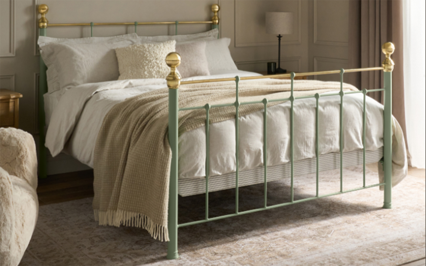 a sage green iron and brass bed with white bedding and a beige throw blanket